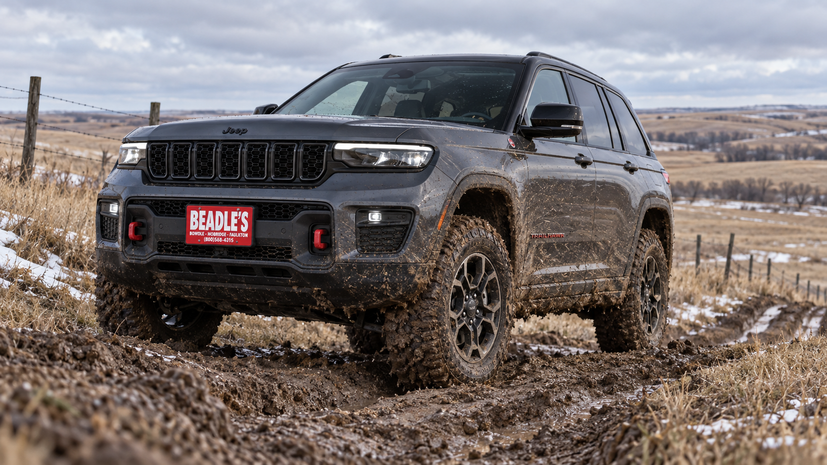 2027 Jeep Grand Cherokee Trailhawk climbing a muddy off-road trail, at Beadle's Chrysler Center