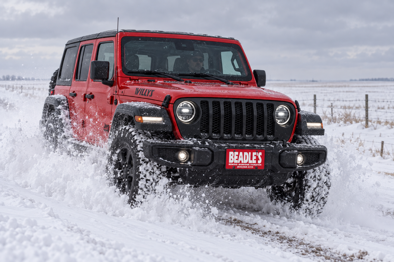 2027 Jeep Wrangler Willys pushing through a snow drift on a South Dakota gravel road, at Beadle's Chrysler Center