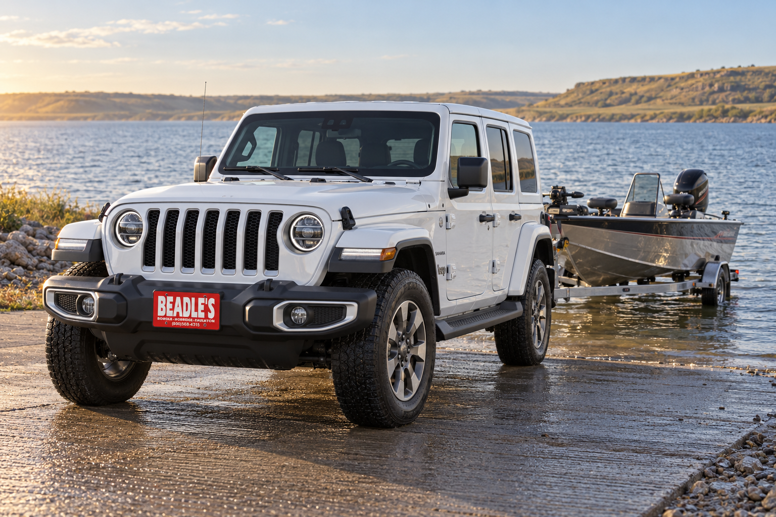 2026 Jeep Wrangler 4-Door backing a fishing boat down a Lake Oahe boat ramp, at Beadle's Chrysler Center