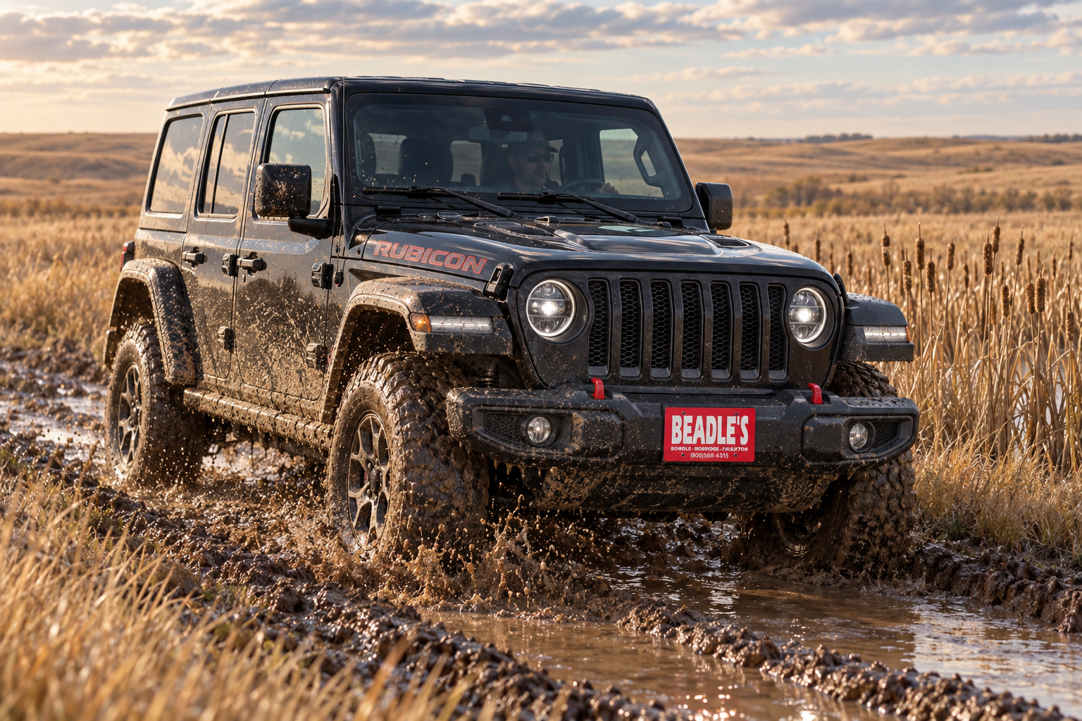Muddy 2027 Jeep Wrangler Rubicon parked at the edge of a South Dakota cattail slough, at Beadle's Chrysler Center